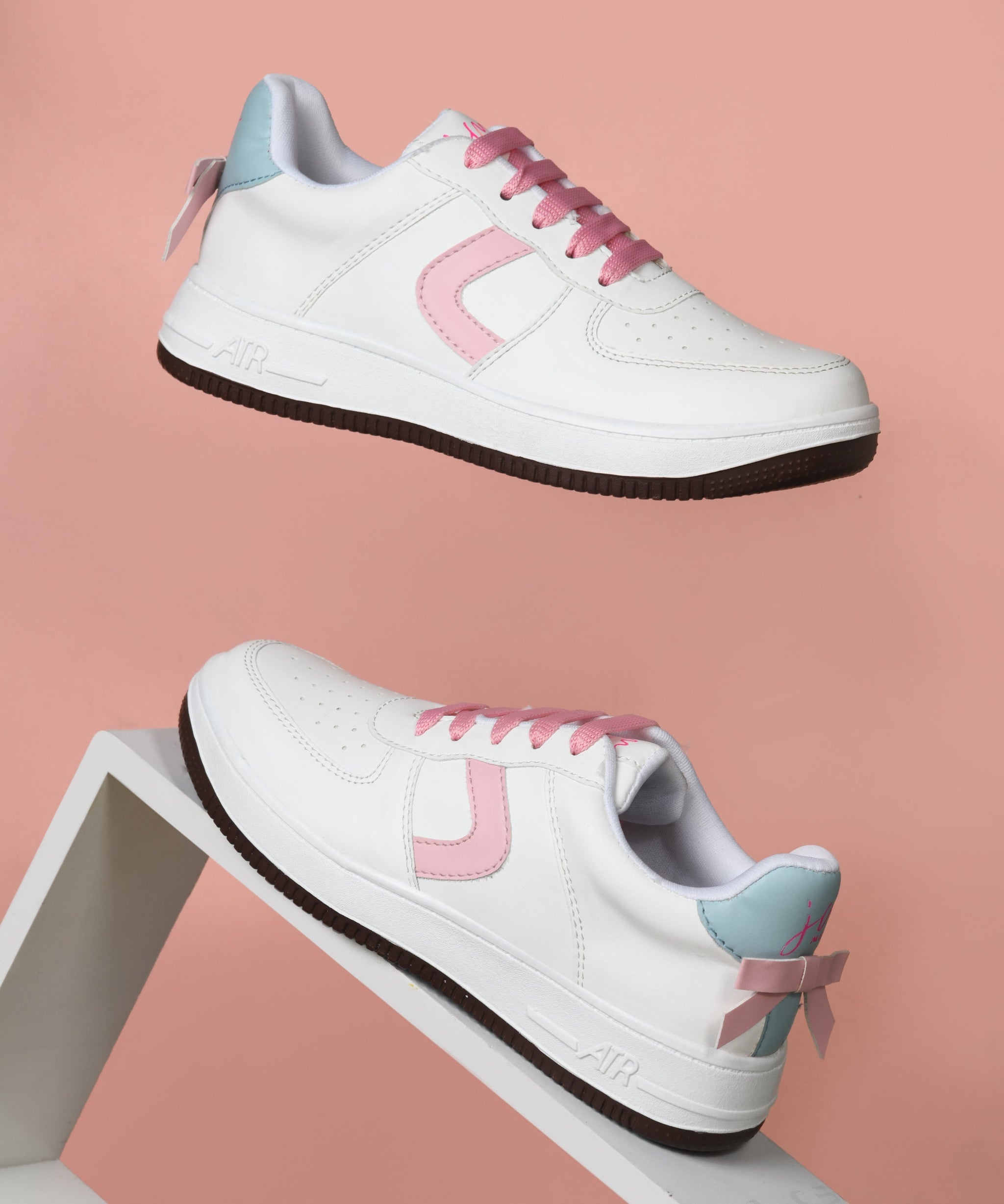 White low top sneakers women with pink laces, curved side panel, perforated toe, and chunky rubber sole.