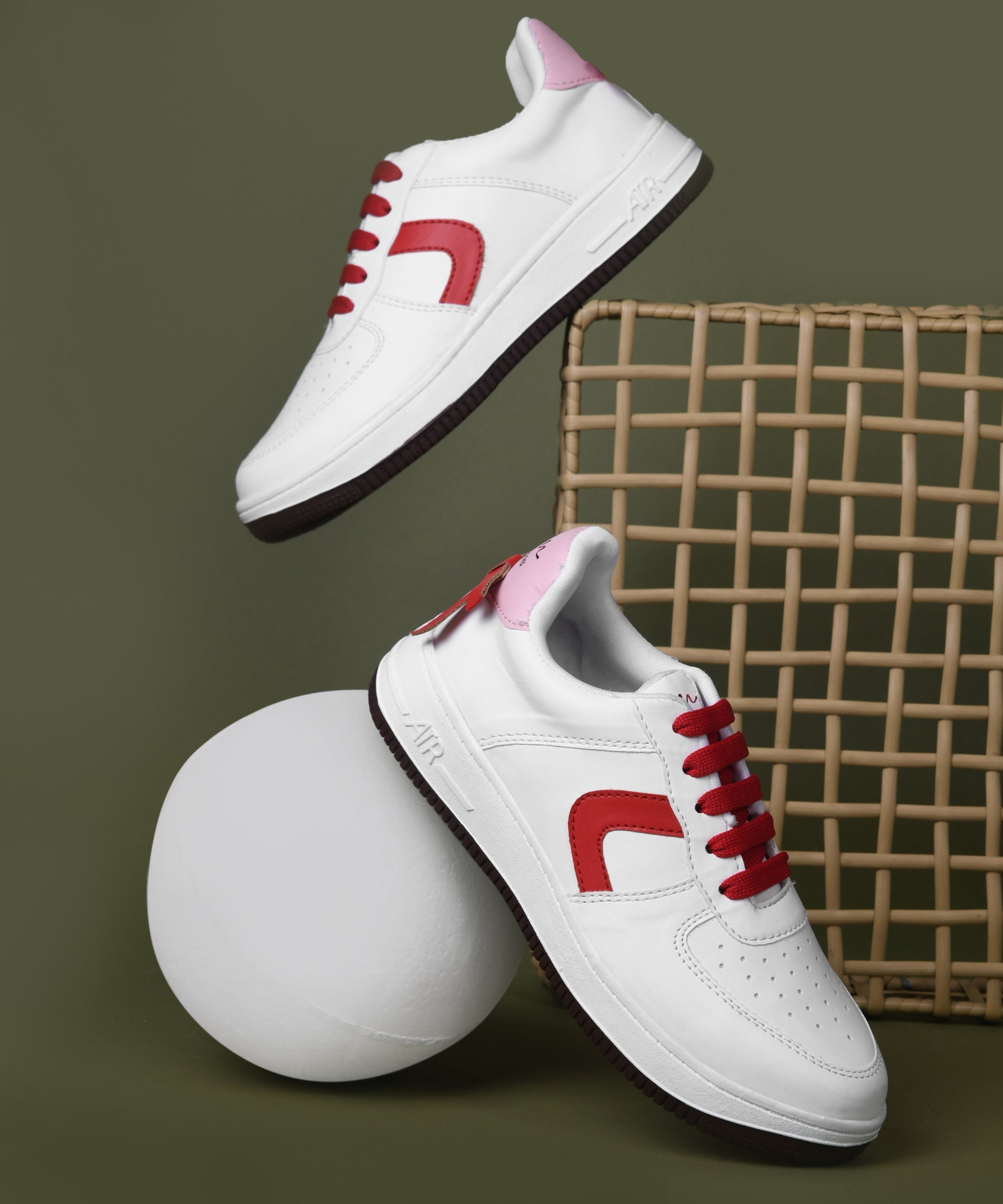 White low top sneakers women with red laces, curved side panel, perforated toe, and chunky rubber sole.
