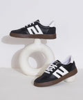 Black-White sneakers for women with white side stripe, gum sole, lace-up front, and padded collar.